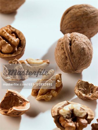 Whole and opened walnuts on white background