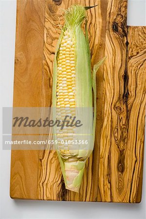 Un épi de maïs avec balles sur une planche de bois