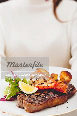 Grilled sirloin steak with lobster and roast potatoes