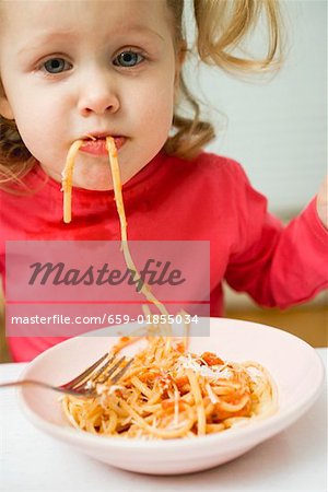 Small girl eating spaghetti