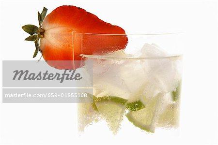 Eau minérale avec des cubes de glace, de fraise et de quartiers de lime