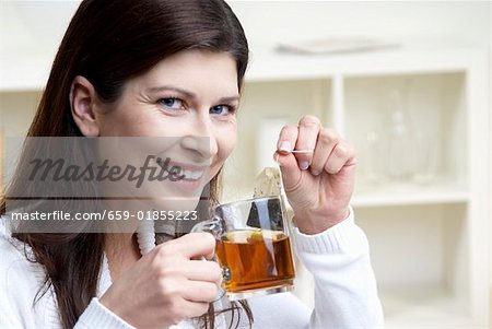 Femme tenant la tasse de thé et sachets de thé dans ses mains