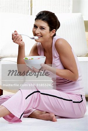 Femme mangeant yaourt avec les kiwis et les fraises