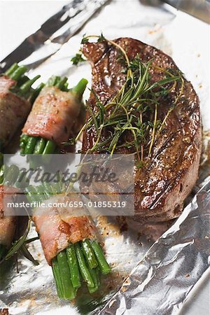 Grilled beef steak with bacon- wrapped beans