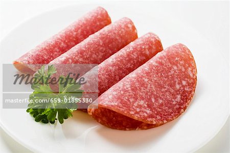 Four slices of salami with parsley