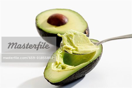 Hollowing out an avocado with a spoon