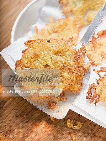 Potato rosti on spatula and kitchen paper