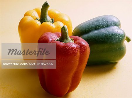 Red, yellow and green peppers with drops of water