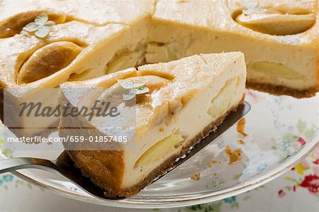 Apple cheesecake, slices taken, with slice on server