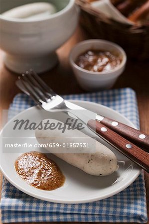 Cooked Weisswurst with mustard on plate