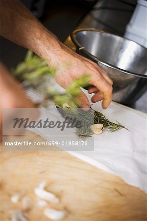 Laying herbs and garlic on kitchen paper