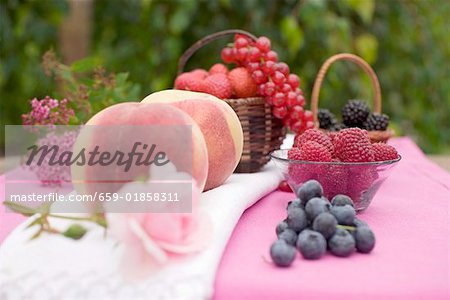 Pfirsiche und frischen Beeren auf Tisch im freien