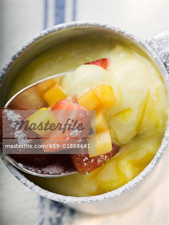 Mango cream with strawberries and icing sugar