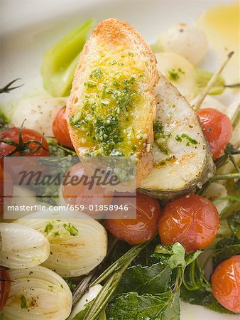 Sea bass cutlet with crostini on roasted vegetables