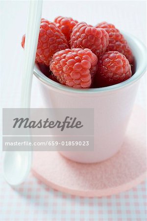 Framboises dans le bécher de poterie, avec cuillère