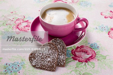 Tasse de cappuccino avec deux coeurs de chocolat