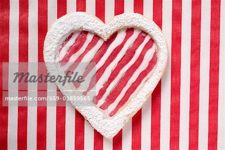 Heart-shaped biscuit with red and white striped icing