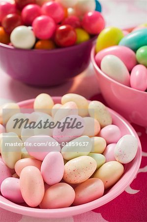 Different kinds of sweets and bubble gum balls in bowls