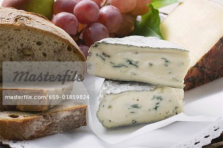 Zwei verschiedene Arten von Käse, roten Trauben und Brot