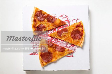 Three slices of pepperoni pizza on pizza box