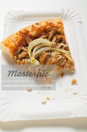 Slice of tuna & onion pizza (a bite taken) on paper plate