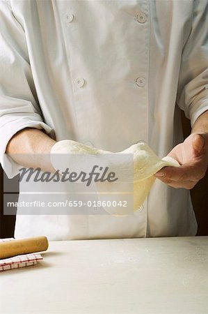 Shaping pizza dough by hand (stretching)