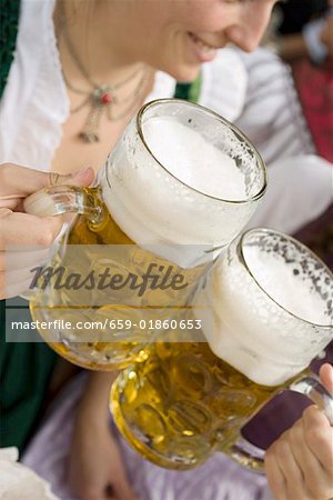 Women clinking litres of beer together (Oktoberfest, Munich) Women clinking litres of beer together (Oktoberfest, Munich)