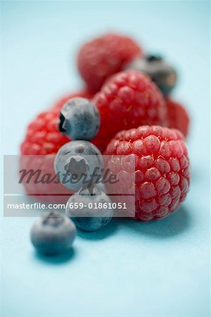 Blueberries and raspberries on blue background