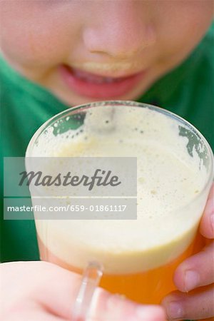 Child drinking a glass of freshly pressed apple juice