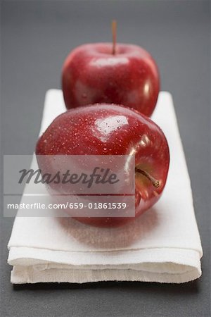 Deux pommes rouges, variété Stark, sur toile de lin Deux pommes rouges, variété Stark, sur toile de lin