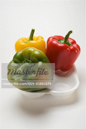 Three peppers (yellow, red, green) in polystyrene tray