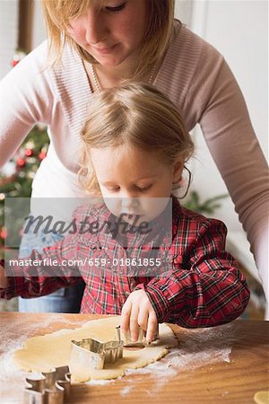 Mother and child cutting out Christmas biscuits