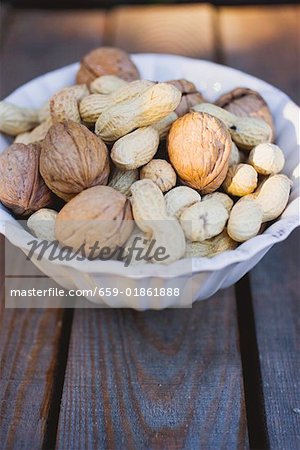Walnuts and peanuts in white bowl
