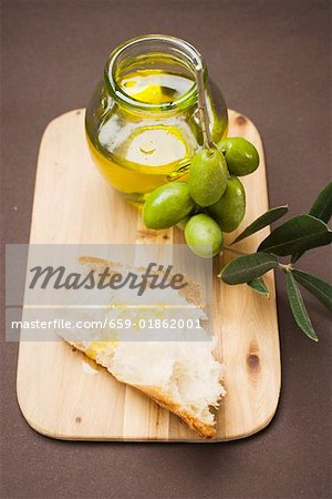 Olive sprig with green olives, white bread and olive oil