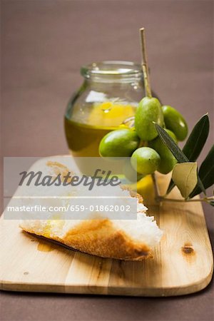 Olive sprig with green olives, white bread and olive oil