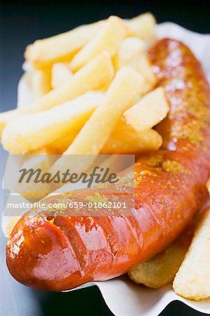 Currywurst (saucisse avec ketchup & cari) & des chips dans le plat de papier