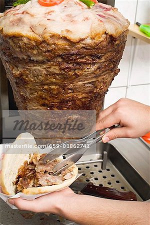 Making a döner kebab: filling pita bread with meat