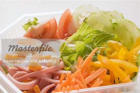 Iceberg lettuce, ham, cheese, egg & vegetables in plastic bowl