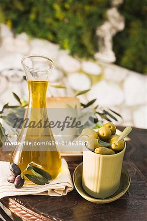 Olives, olive oil, cheese & crackers on table out of doors