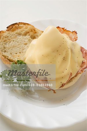 Englische Muffins mit gebratenem Ei, Speck, & Käse-Sauce (USA)