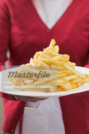 Waitress serving plate piled high with chips