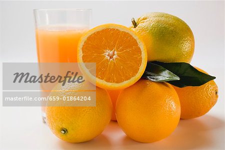 Glass of orange juice and several oranges Glass of orange juice and several oranges