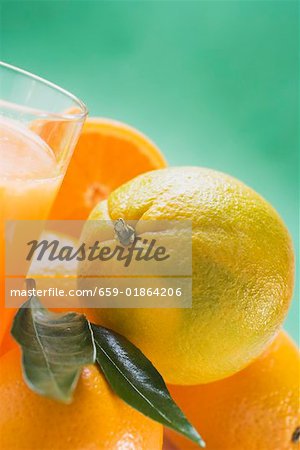 Plusieurs oranges à côté du verre de jus d'orange Plusieurs oranges à côté du verre de jus d'orange