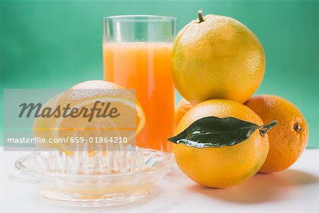 Verre de jus d'orange, plusieurs oranges et presse-agrumes citrus Verre de jus d'orange, plusieurs oranges et presse-agrumes citrus