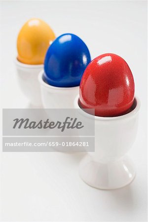 Trois oeufs colorés dans les coquetiers