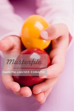 Child's hands holding two Easter eggs
