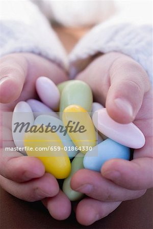 Child's hands holding sugared almonds