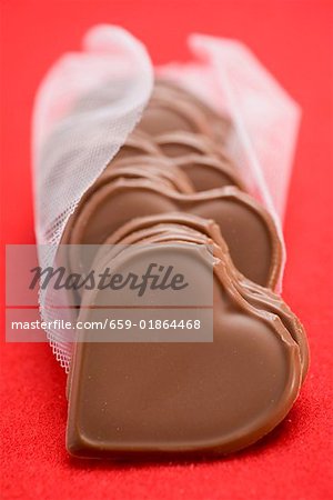 Coeurs de chocolat sur fond rouge