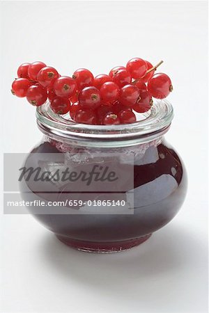 Jar of redcurrant jelly, fresh redcurrants on top of jar