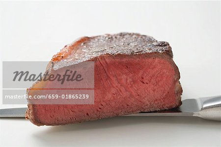 Steak de bœuf, montrant coupe le bord, sur le couteau
